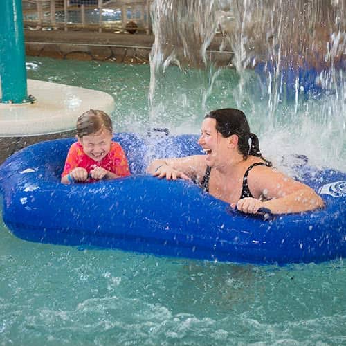 Mom and daughter under waterfall in lazy river