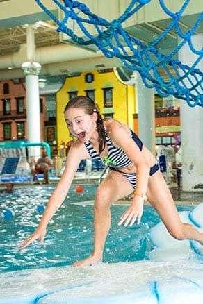 Teen girl balancing across glaciers in indoor waterpark