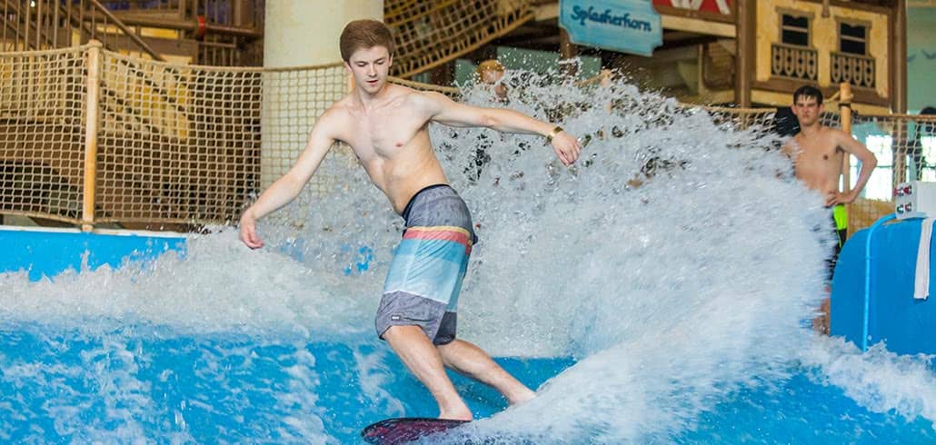 Boy surfing at indoor water park