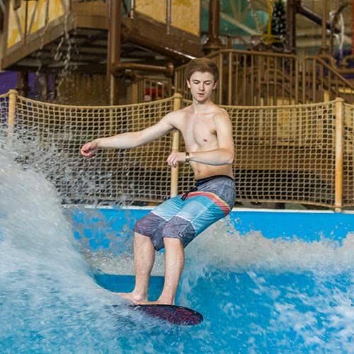 kid surfing on Surf simulator at indoor water park