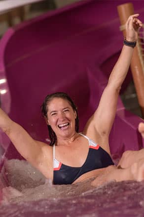 Woman with arms up on waterslide
